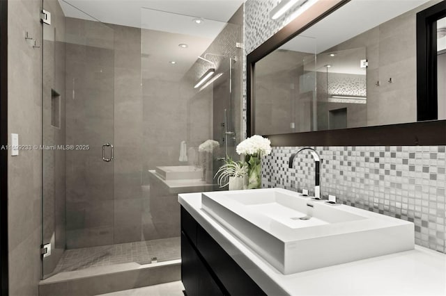 bathroom with tasteful backsplash, vanity, tile walls, and a shower with shower door