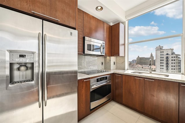 kitchen featuring decorative backsplash, appliances with stainless steel finishes, a wealth of natural light, and sink