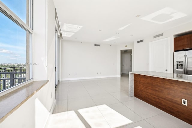 unfurnished room with plenty of natural light and light tile patterned floors