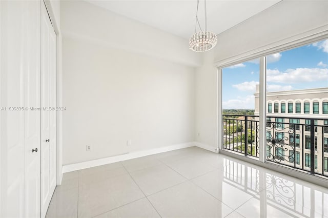 unfurnished room with a notable chandelier and light tile patterned floors