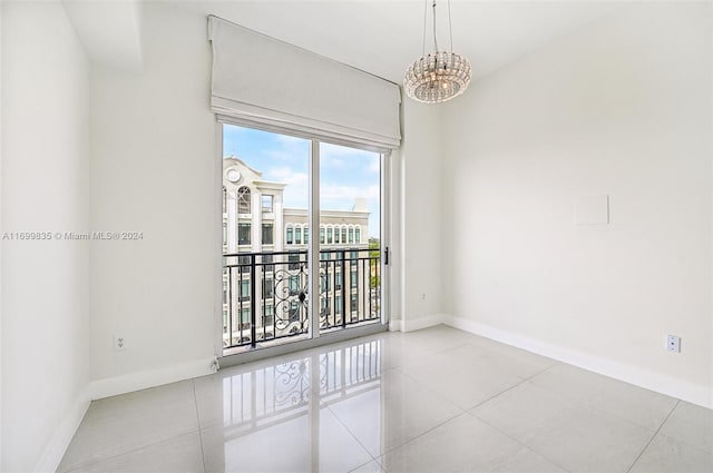 empty room with light tile patterned floors and a chandelier