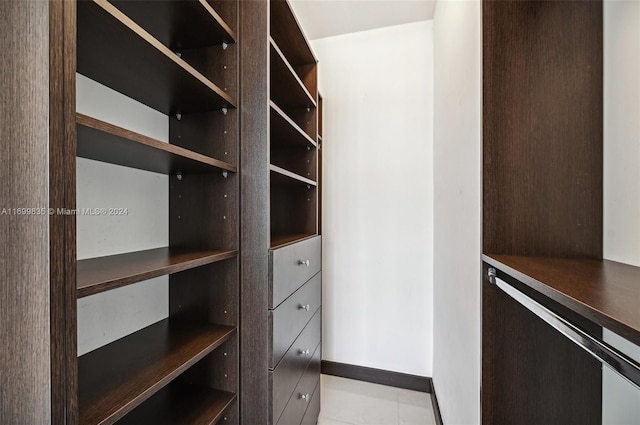 walk in closet with light tile patterned flooring