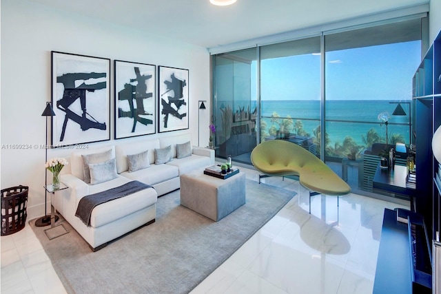 living room with tile patterned flooring, a water view, and a wall of windows