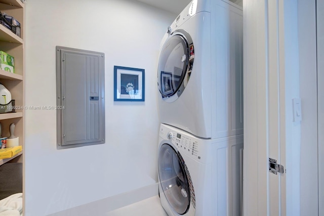 laundry area with electric panel and stacked washer / drying machine