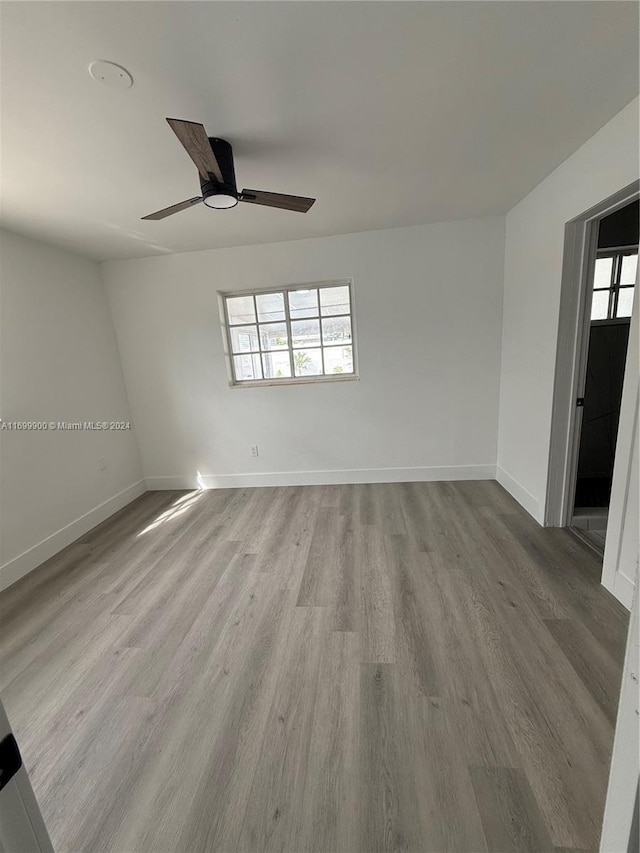 empty room featuring light wood-type flooring, a wealth of natural light, and ceiling fan