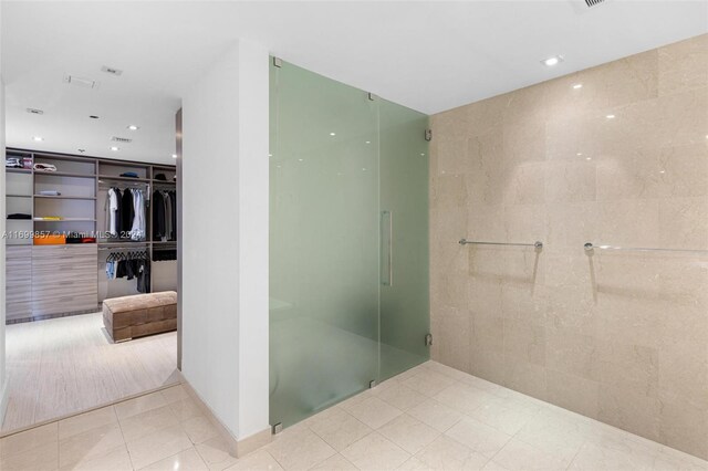 bathroom featuring walk in shower and tile walls