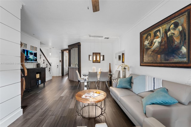 living room with dark hardwood / wood-style floors and crown molding