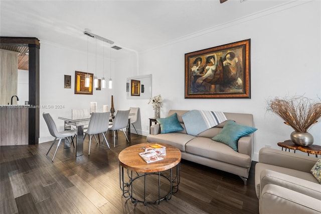 living room featuring dark hardwood / wood-style flooring and crown molding