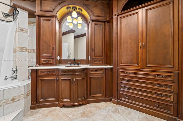 bathroom with tile patterned flooring, tiled shower / bath combo, ornamental molding, and vanity