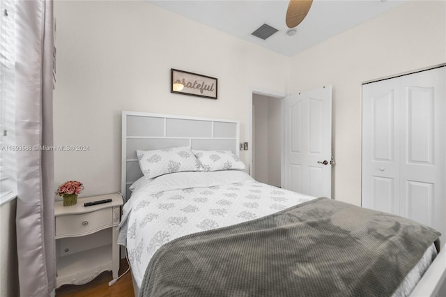 bedroom featuring dark hardwood / wood-style flooring, ceiling fan, and a closet