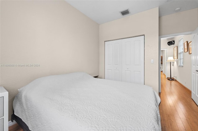 bedroom with a closet and hardwood / wood-style floors