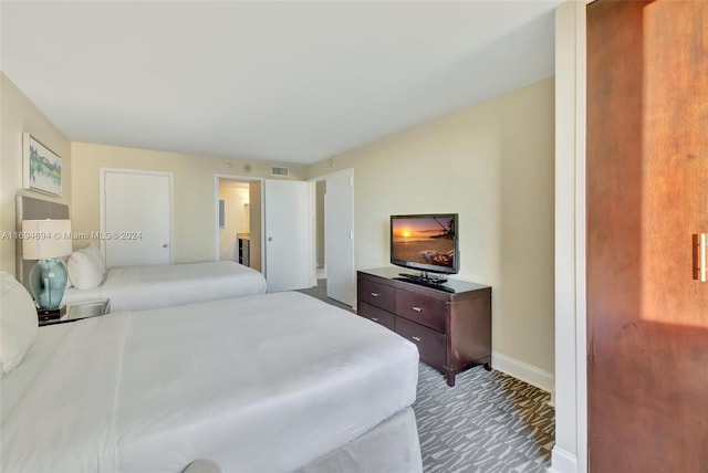 carpeted bedroom featuring ensuite bathroom