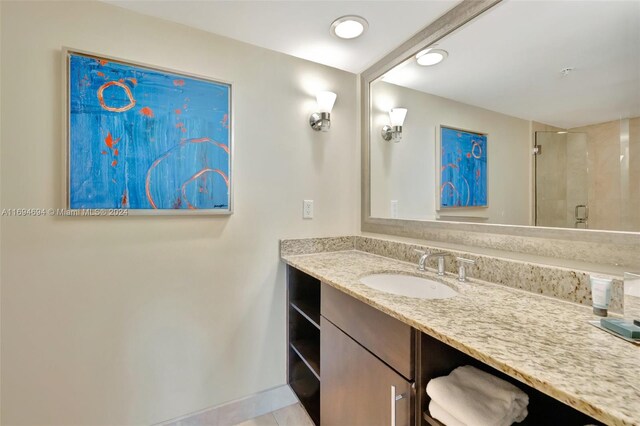 bathroom featuring tile patterned flooring, vanity, and a shower with door