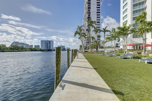 view of dock with a water view and a yard