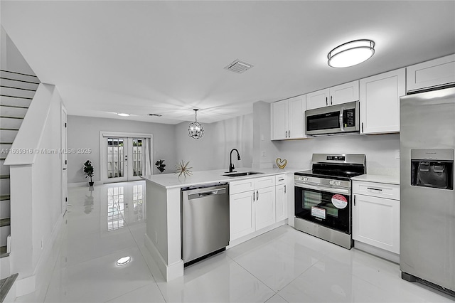 kitchen featuring white cabinets, sink, hanging light fixtures, kitchen peninsula, and stainless steel appliances