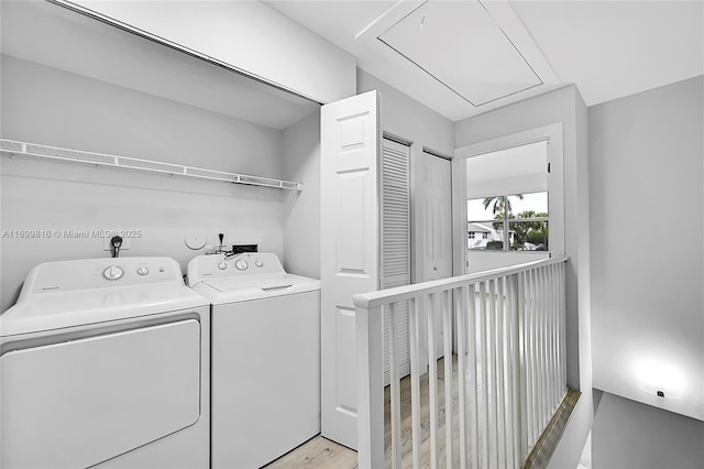 laundry area featuring separate washer and dryer and light hardwood / wood-style flooring