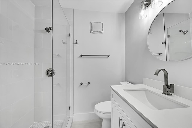 bathroom with vanity, a tile shower, and toilet