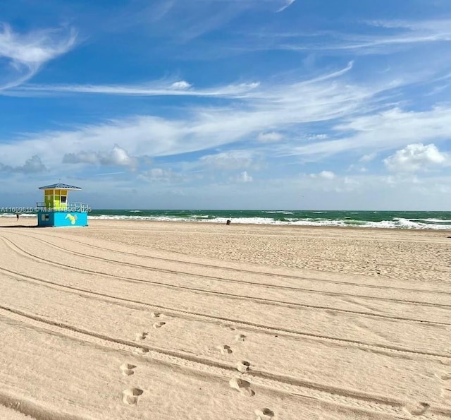 view of community with a water view and a beach view