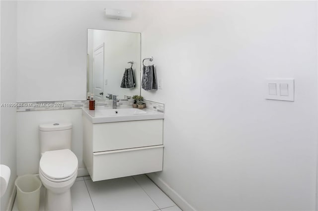 bathroom with toilet, vanity, and tile patterned floors