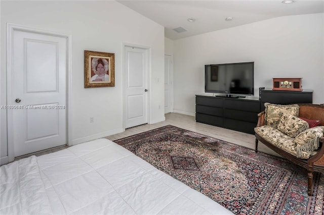 bedroom with a closet, lofted ceiling, and light wood-type flooring