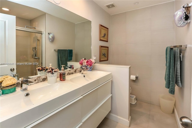 bathroom featuring tile patterned floors, vanity, and a shower with shower door