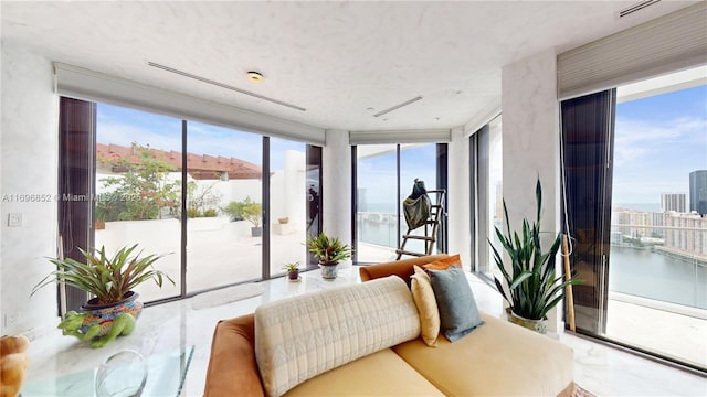 sunroom featuring a water view