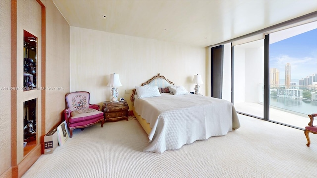 bedroom with access to outside, a wall of windows, and light colored carpet