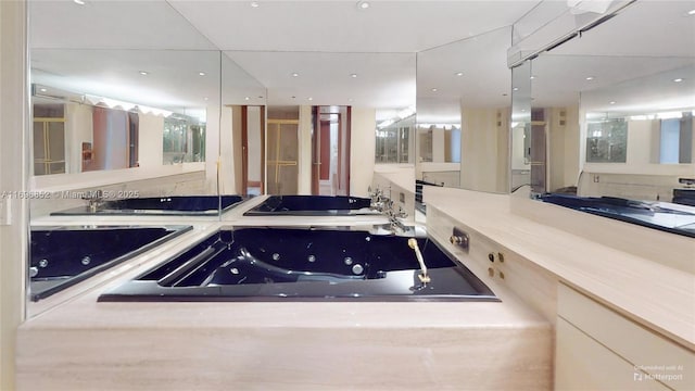 bathroom featuring vanity and tiled bath