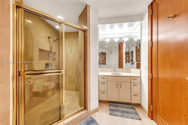 bathroom featuring a shower with door, vanity, and tile patterned flooring