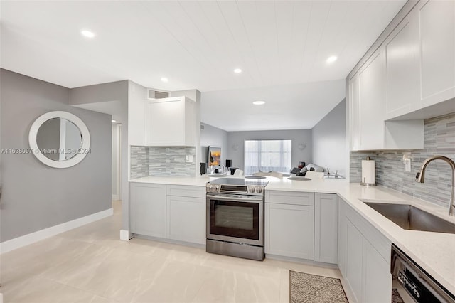 kitchen featuring sink, light tile patterned floors, tasteful backsplash, kitchen peninsula, and stainless steel appliances