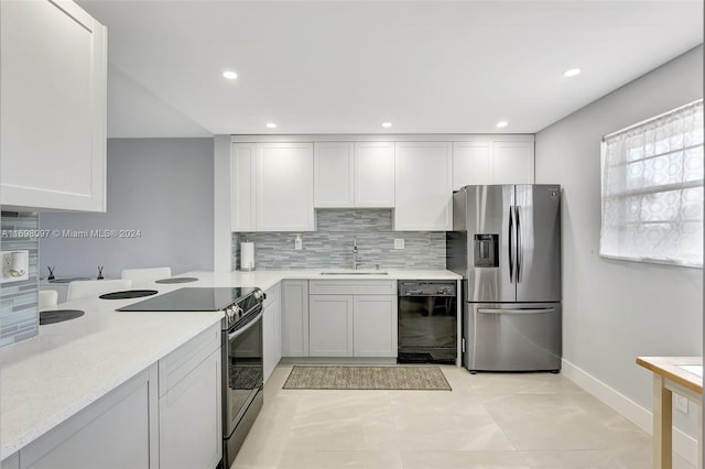 kitchen featuring sink, tasteful backsplash, light tile patterned flooring, white cabinetry, and stainless steel appliances