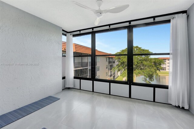 spare room with floor to ceiling windows, ceiling fan, and plenty of natural light