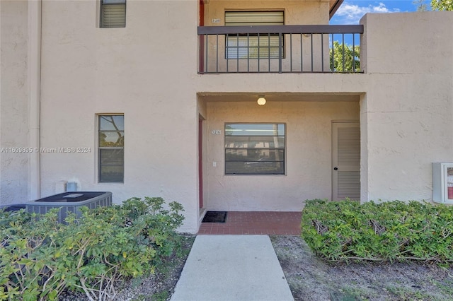 entrance to property featuring cooling unit and a balcony