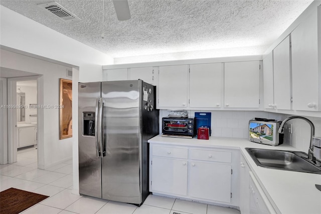 kitchen featuring sink, stainless steel fridge with ice dispenser, decorative backsplash, a textured ceiling, and white cabinetry