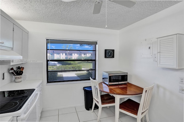 tiled dining room with ceiling fan and a textured ceiling