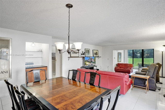 dining space featuring a notable chandelier, light tile patterned floors, and a textured ceiling