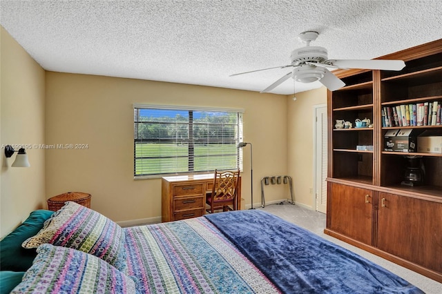 bedroom featuring ceiling fan, a textured ceiling, and light carpet