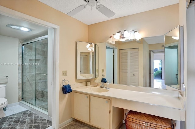 bathroom with ceiling fan, walk in shower, a textured ceiling, toilet, and vanity