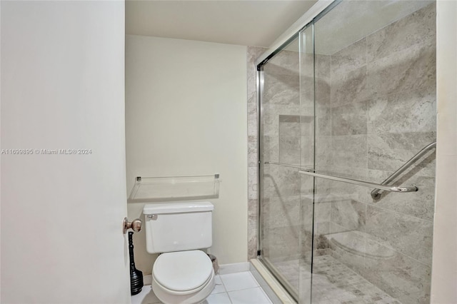 bathroom with tile patterned flooring, toilet, and an enclosed shower