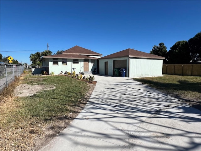 view of front of home featuring a front lawn, an outdoor structure, and a garage