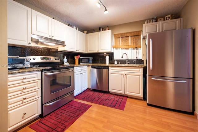 kitchen with white cabinets, a textured ceiling, and appliances with stainless steel finishes