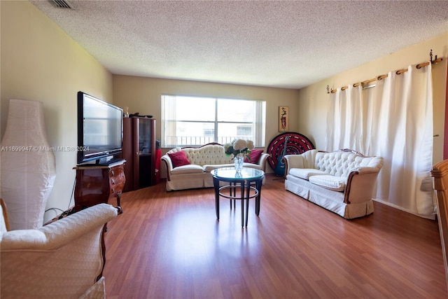 living room with hardwood / wood-style floors and a textured ceiling