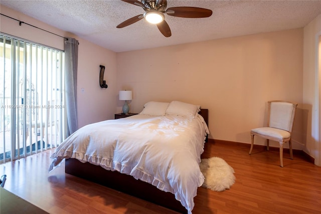 bedroom with wood-type flooring, a textured ceiling, and ceiling fan