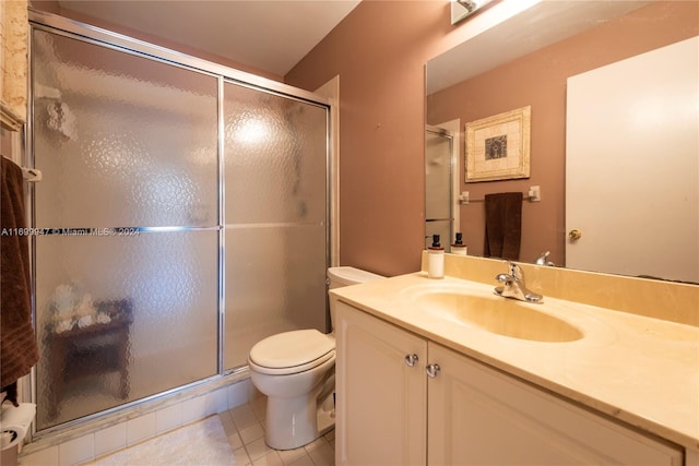 bathroom featuring tile patterned floors, vanity, toilet, and a shower with shower door