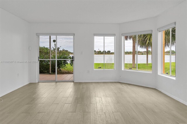 spare room with a water view and light wood-type flooring