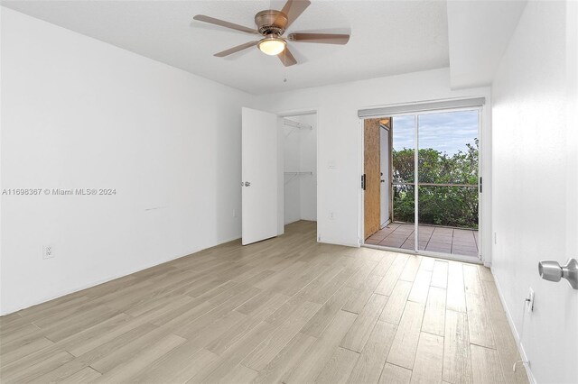 empty room with ceiling fan and light hardwood / wood-style flooring