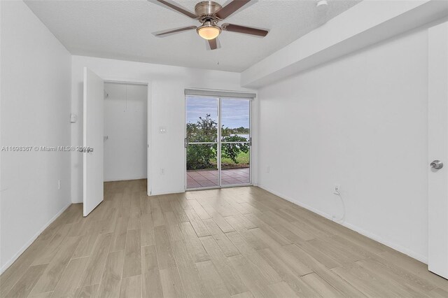 unfurnished bedroom with access to exterior, ceiling fan, light hardwood / wood-style flooring, and a textured ceiling