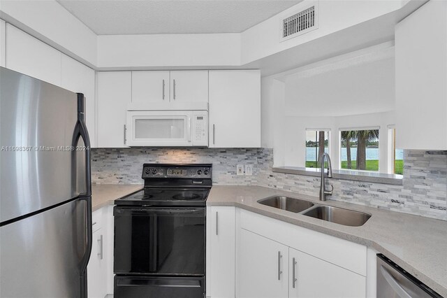 kitchen featuring sink, a textured ceiling, appliances with stainless steel finishes, tasteful backsplash, and white cabinetry