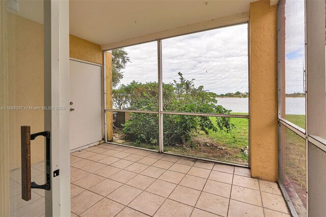 unfurnished sunroom with a water view