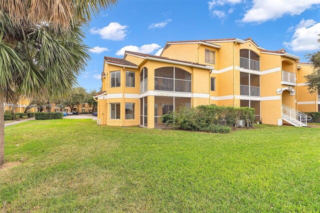 rear view of property featuring a lawn